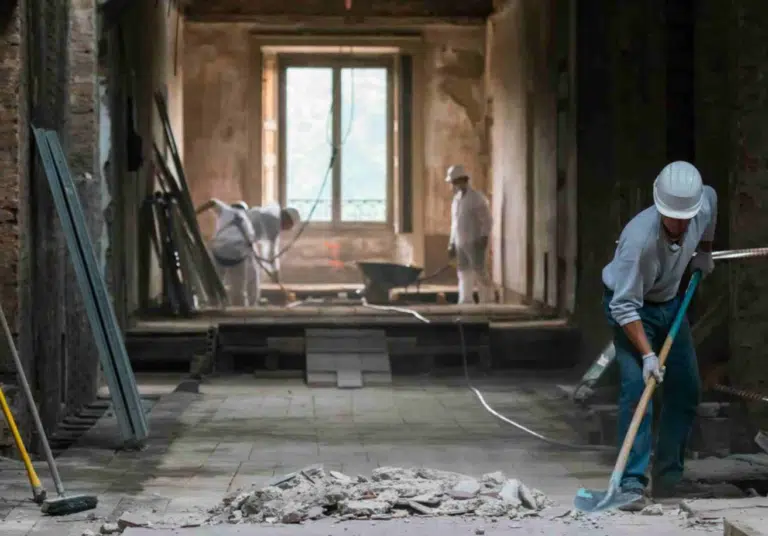 Worker clearing debris from a damaged room